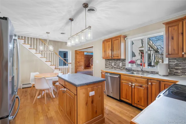 a spacious kitchen with stainless steel appliances granite countertop a sink stove and wooden floor