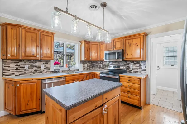 a kitchen with stainless steel appliances granite countertop a sink a stove and a wooden floors