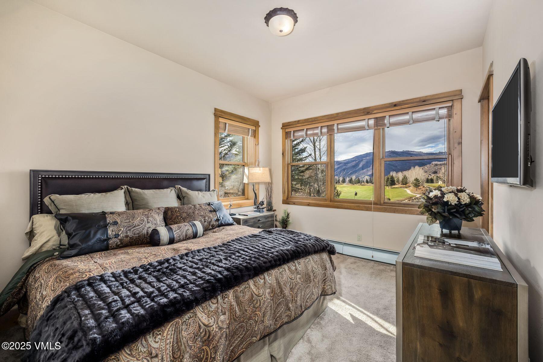 33 Legends Court Edwards, CO 81632 - Photo 34 of 50 a bedroom with a large bed and a flat tv screen on dresser