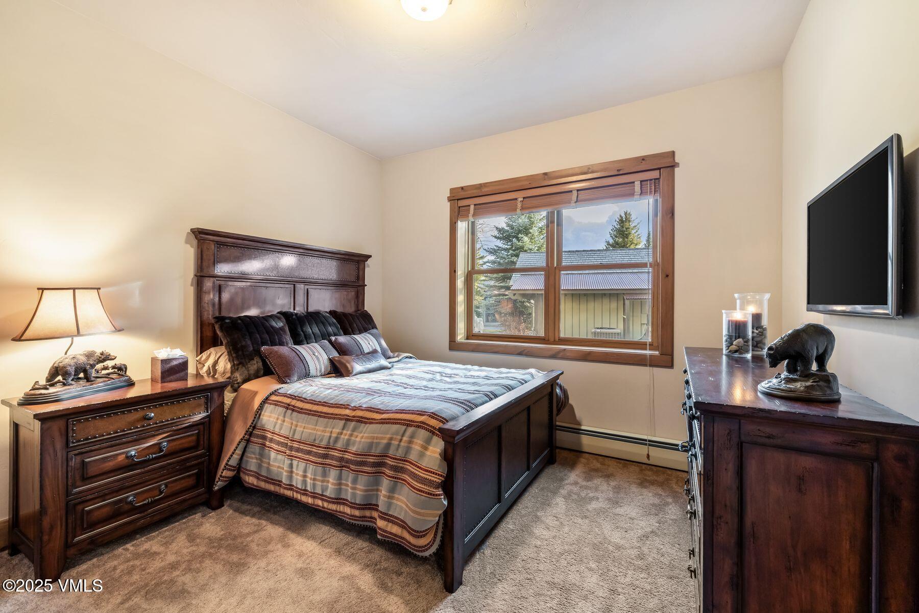 33 Legends Court Edwards, CO 81632 - Photo 36 of 50 a bedroom with a bed and a flat tv screen on a dresser