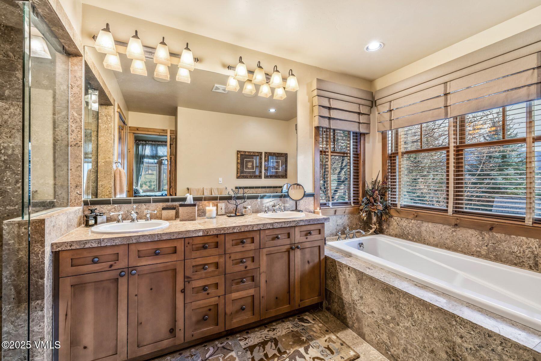 33 Legends Court Edwards, CO 81632 - Photo 9 of 50 a spacious bathroom with a double vanity sink a large mirror and a bathtub