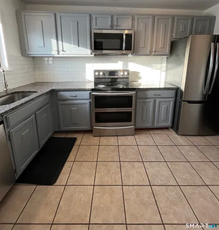 a kitchen with stainless steel appliances a stove sink and cabinets