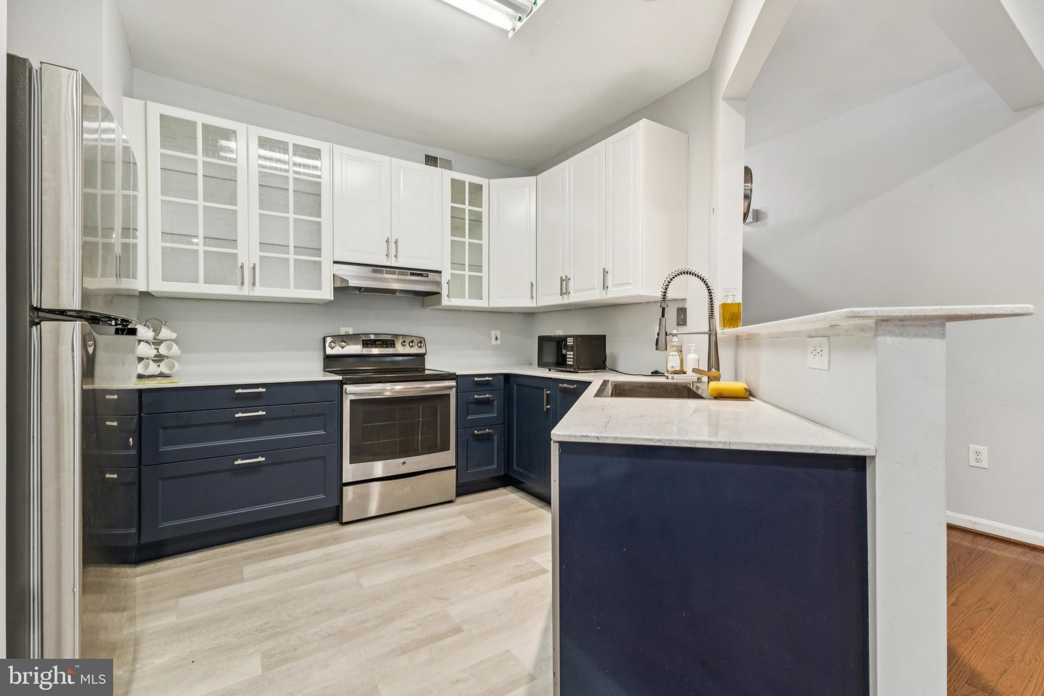 43067 Candlewick Square Leesburg, VA 20176 - Photo 11 of 25 a kitchen with stainless steel appliances granite countertop a sink stove and refrigerator