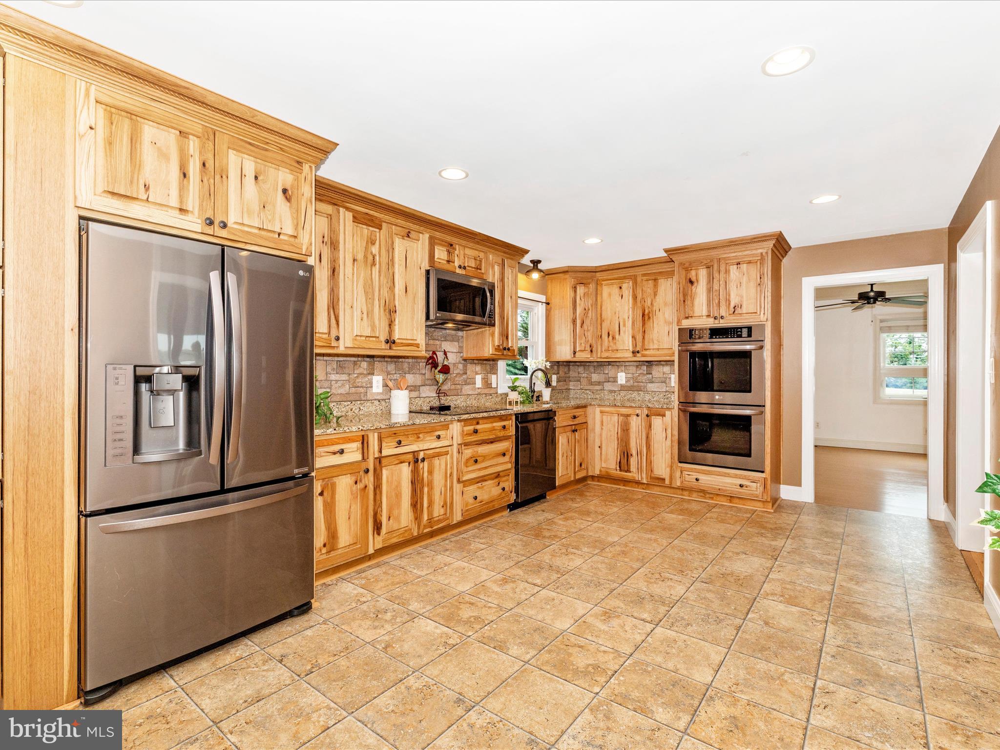 8429 Woodville Road Mount Airy, MD 21771 - Photo 12 of 75 a kitchen with stainless steel appliances granite countertop a refrigerator and a stove top oven