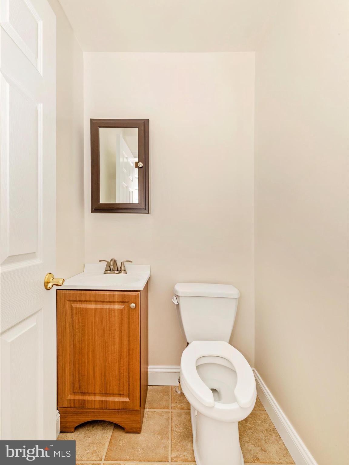 8429 Woodville Road Mount Airy, MD 21771 - Photo 32 of 75 a bathroom with a toilet a sink and mirror