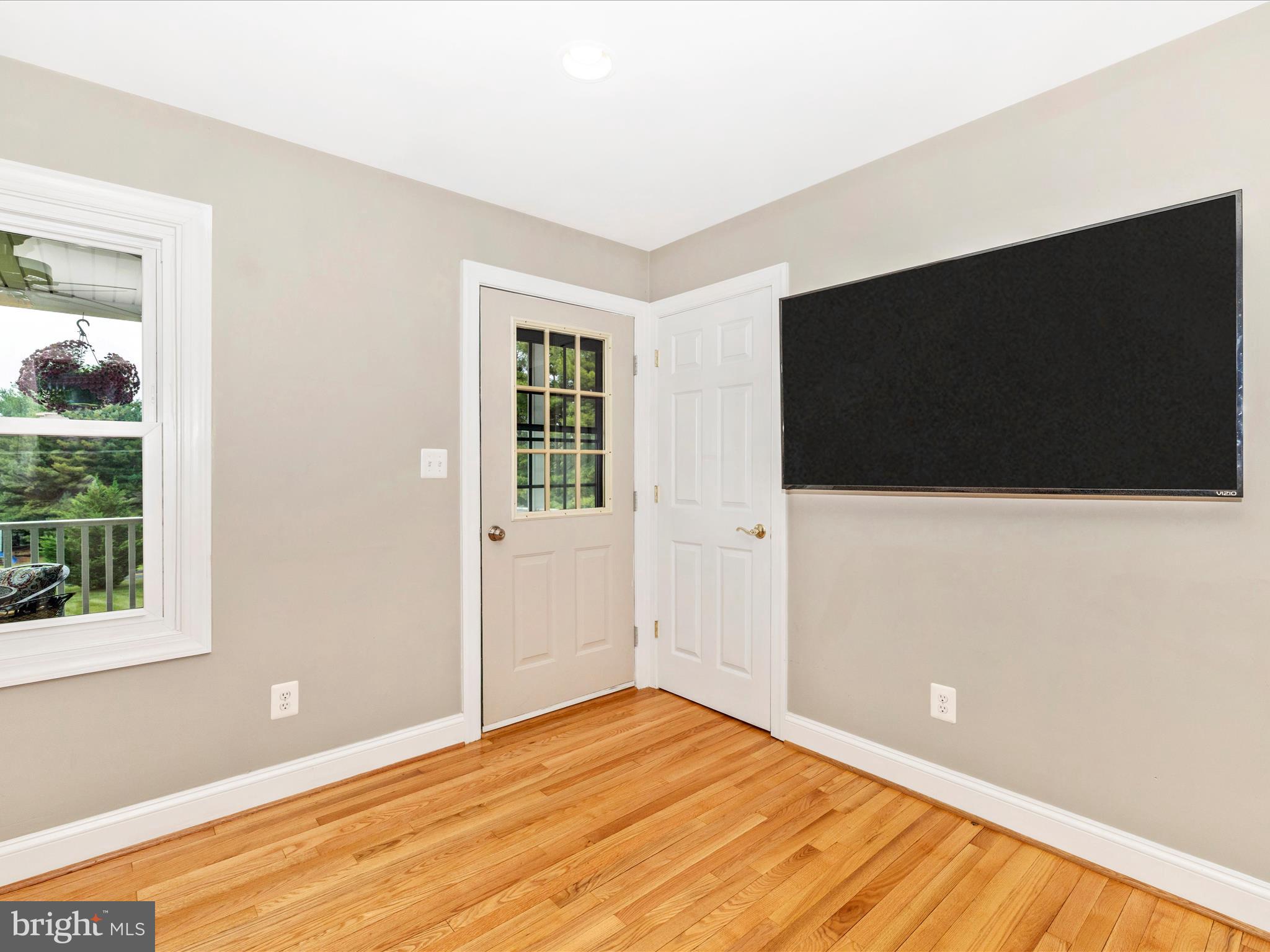 8429 Woodville Road Mount Airy, MD 21771 - Photo 7 of 75 a view of an empty room with wooden floor and windows