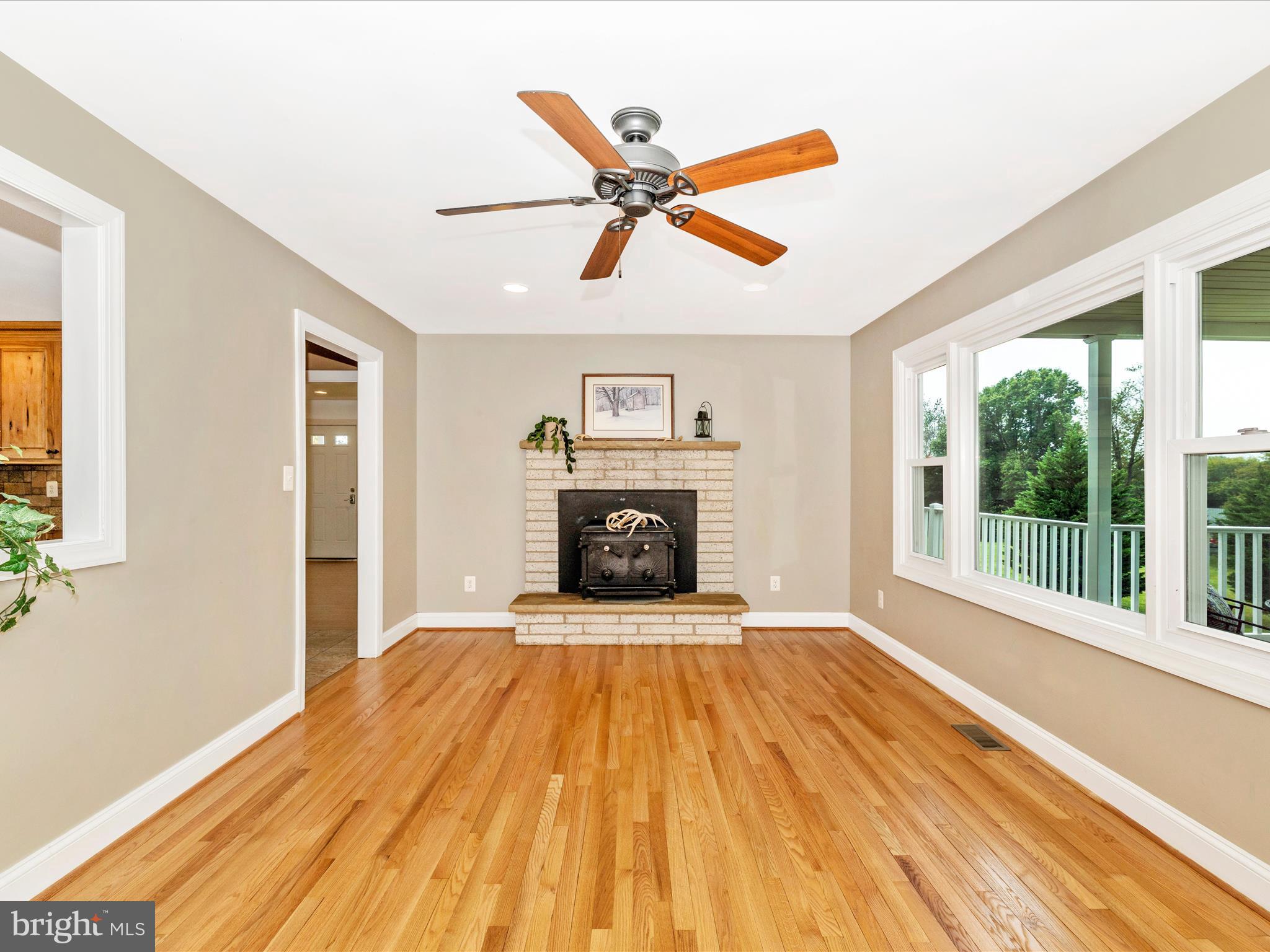8429 Woodville Road Mount Airy, MD 21771 - Photo 9 of 75 a view of a livingroom with a fireplace a ceiling fan and wooden floor