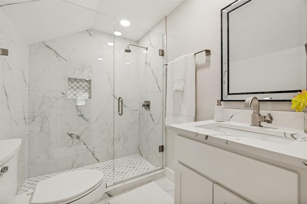 2006 Marydale Road Dallas, TX 75208 - Photo 35 of 40 Walk-in shower with clear glass enclosure and marble-look tile surround