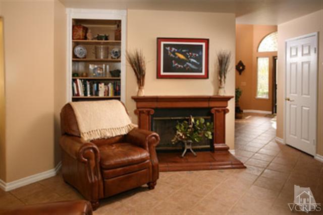 554 Innwood Road Simi Valley, CA 93065 - Photo 7 of 23 a living room with furniture a bookshelf and a fireplace