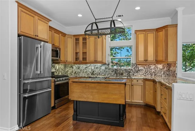a kitchen with stainless steel appliances granite countertop a refrigerator and a sink