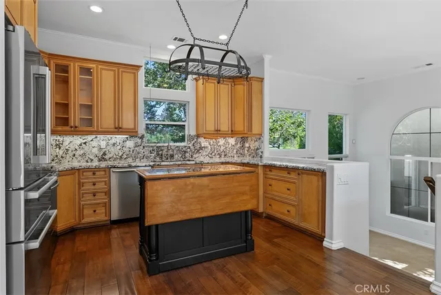 a kitchen with stainless steel appliances granite countertop wooden floors and granite counter tops