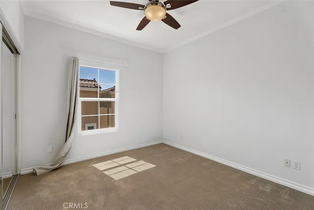 an empty room with a window and a ceiling fan