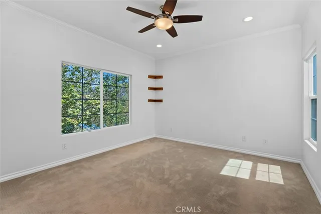 an empty room with a window and a ceiling fan