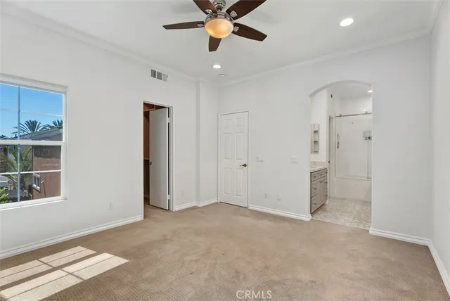 a view of an empty room with window and cabinet