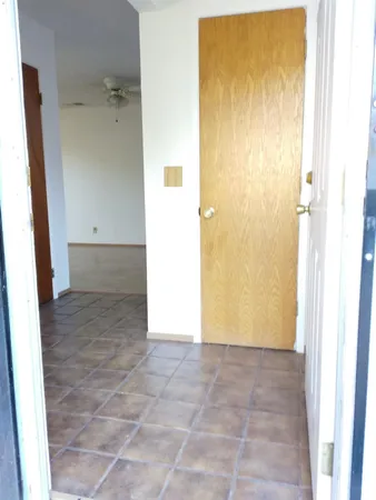 an empty room with a window and ceiling fan