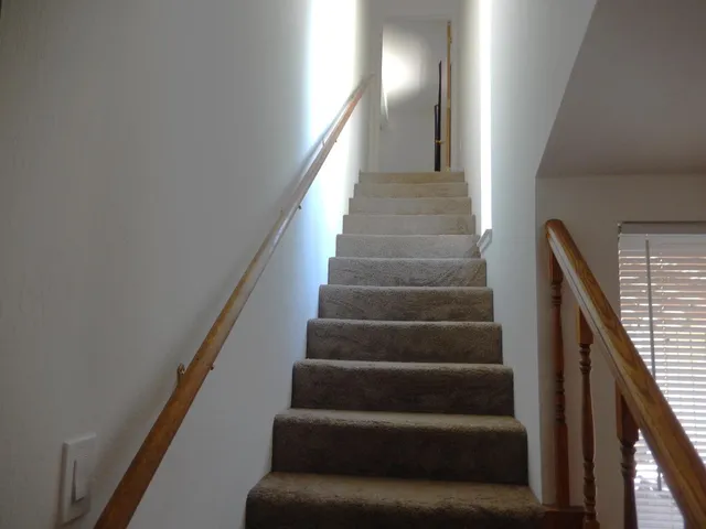 a balcony with table and chairs and wooden fence