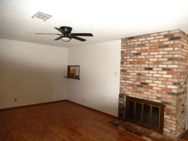 a kitchen with granite countertop a stove a sink and a white cabinets