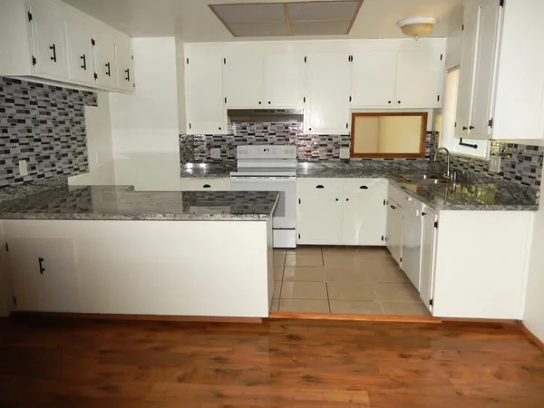 a stove top oven sitting inside of a kitchen