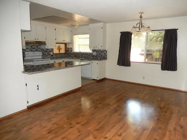 a view of a room with wooden floor and large window