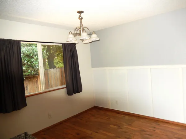 a view of a small space with wooden floor and a ceiling fan