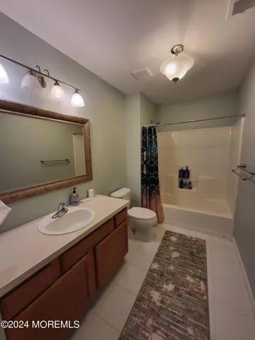 a spacious bathroom with a sink a toilet a mirror and shower