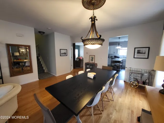 a view of a livingroom and dining room with a table wooden floor