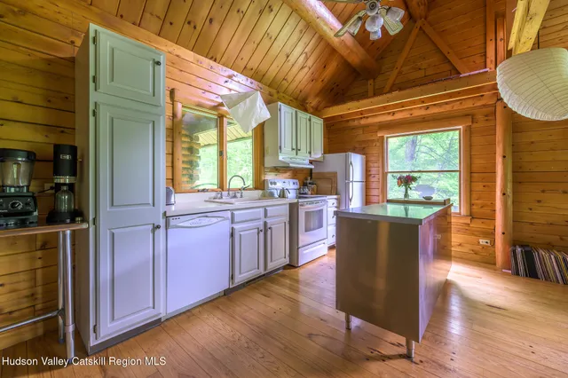 a kitchen with stainless steel appliances granite countertop wooden floors wooden cabinets a dining table and chairs