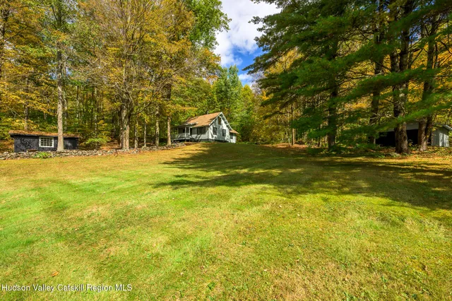 a swimming pool that has lawn chairs under an umbrella