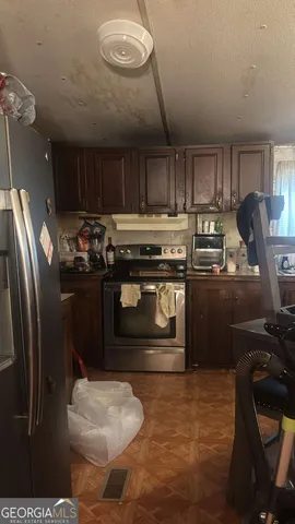 a kitchen with stainless steel appliances granite countertop a stove a refrigerator and a sink