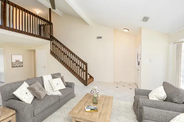a living room with furniture and stairs