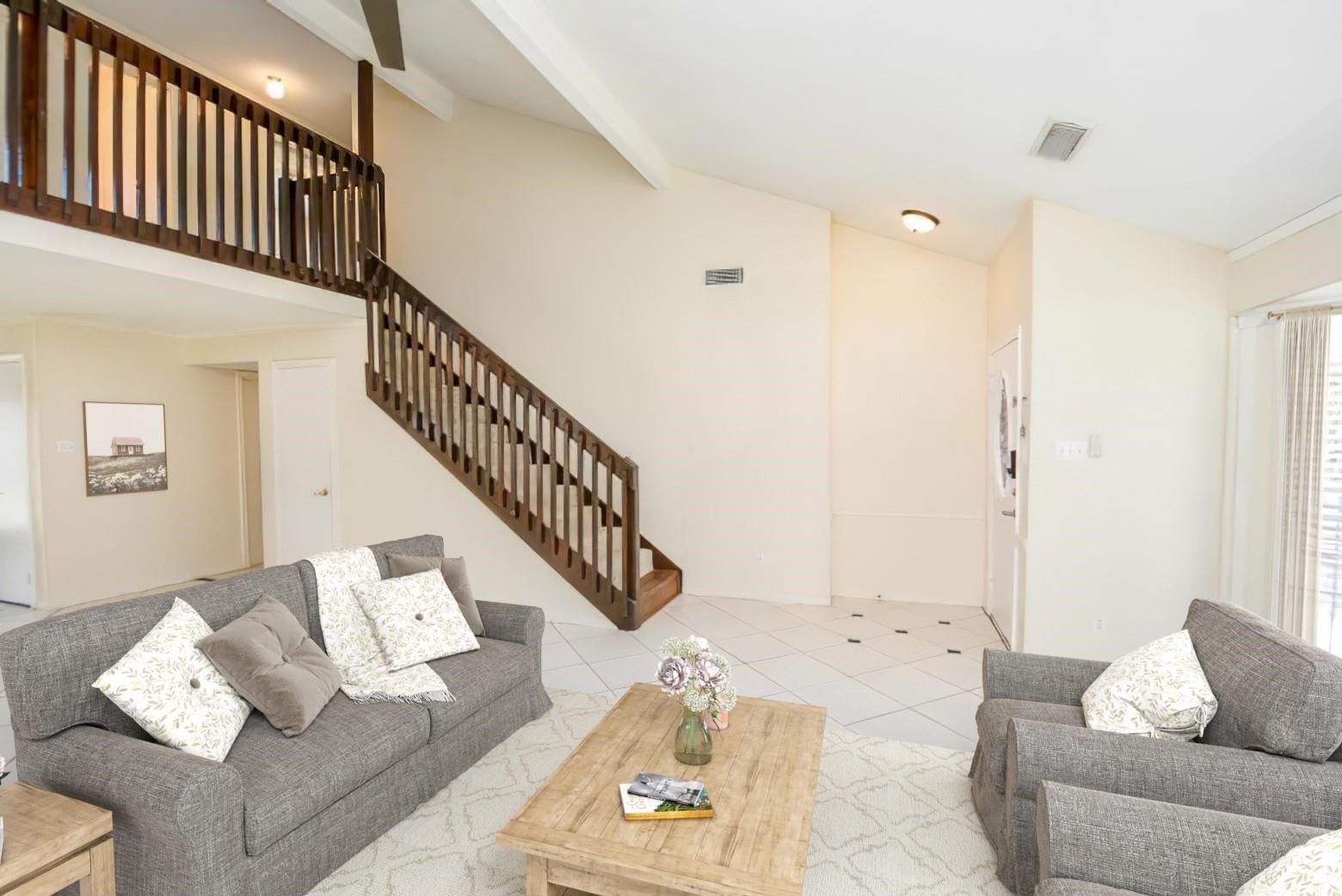 a living room with furniture and stairs