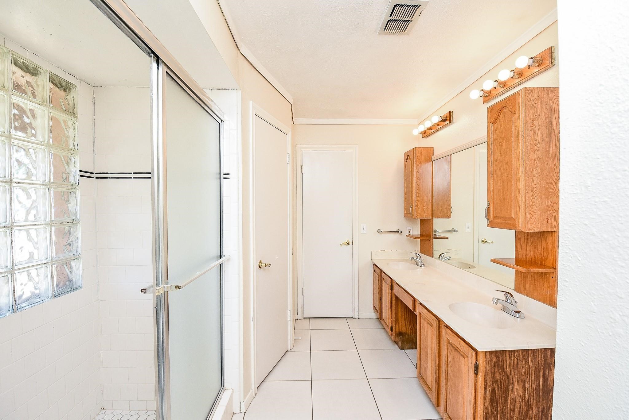 2623 Forestbrook Drive Spring, TX 77373 - Photo 13 of 27 a bathroom with a double vanity sink a mirror and a bathtub
