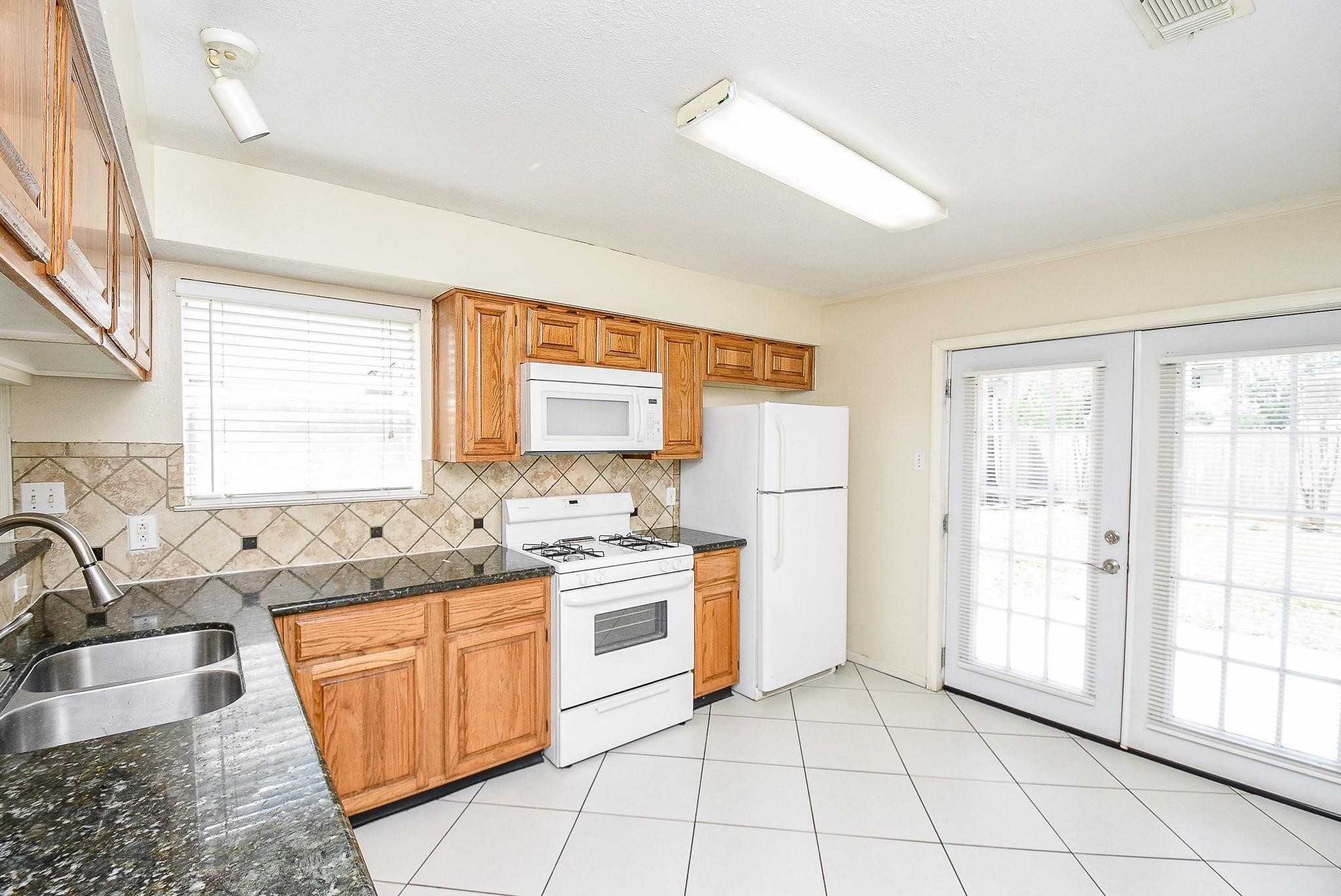 2623 Forestbrook Drive Spring, TX 77373 - Photo 8 of 27 a kitchen with a stove a sink and a refrigerator