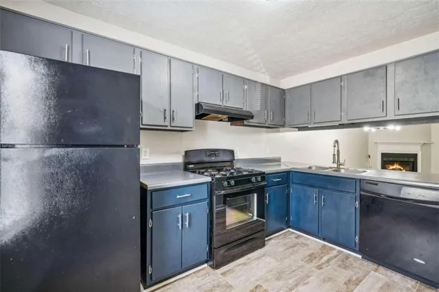 a kitchen with stainless steel appliances granite countertop a stove a refrigerator and a sink