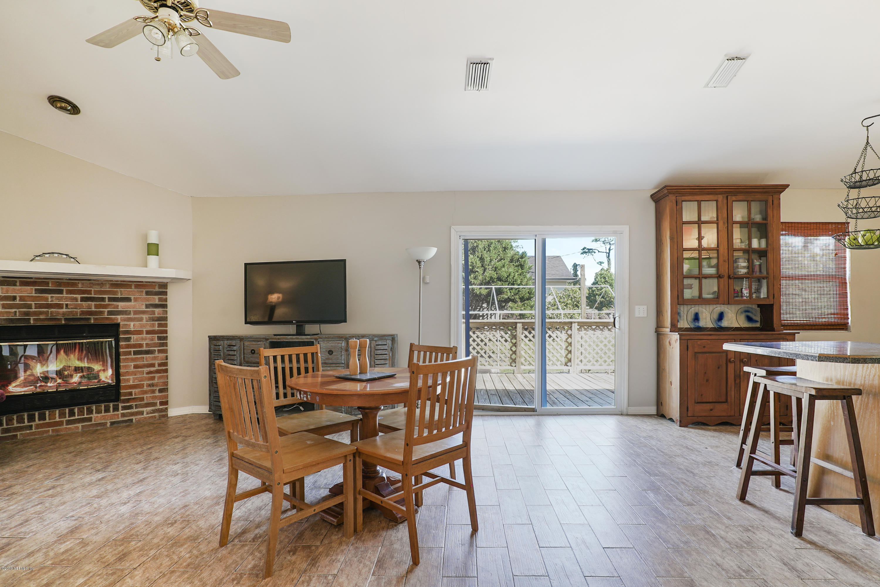 116 Harvard Road St. Augustine, FL 32086 - Photo 10 of 18 a dining room with furniture a fireplace and wooden floor