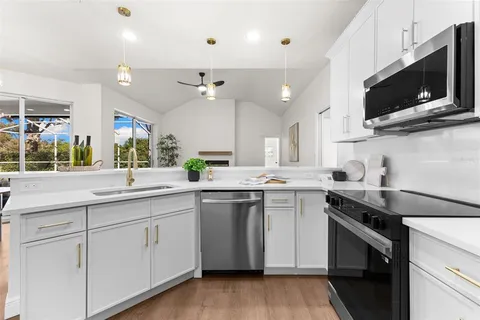 a kitchen with a sink a microwave and cabinets