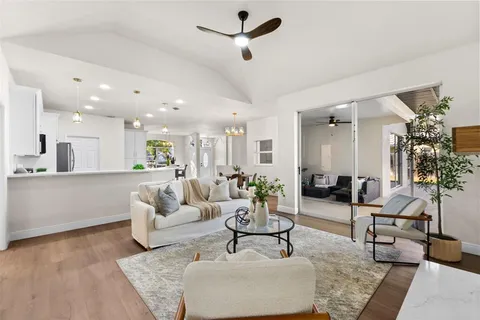 a living room with furniture and a view of kitchen