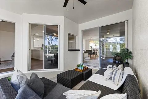 a large white kitchen with a large window and chandelier