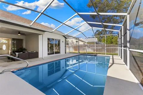 a view of a swimming pool with a tub and wooden fence