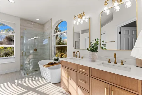 a spacious bathroom with a double vanity sink a large mirror and a shower