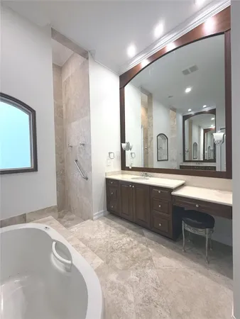 a spacious bathroom with a tub sink and mirror