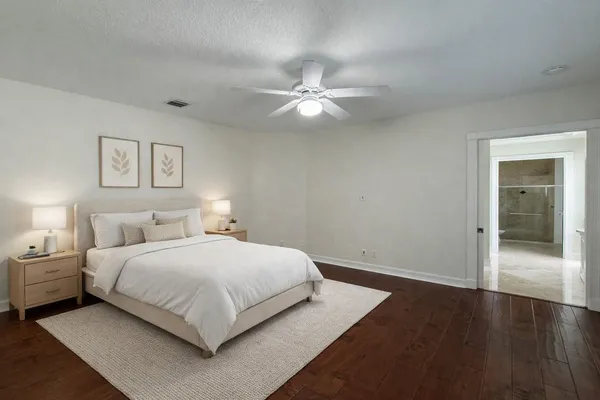 a bedroom with a large bed and a ceiling fan