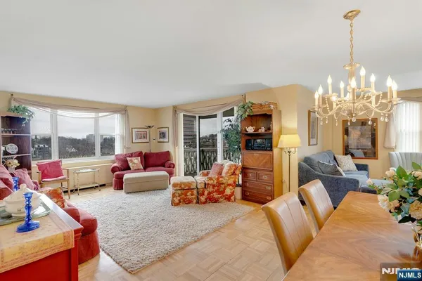 a living room with furniture large window and a chandelier