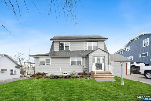 a front view of a house with a garden and yard