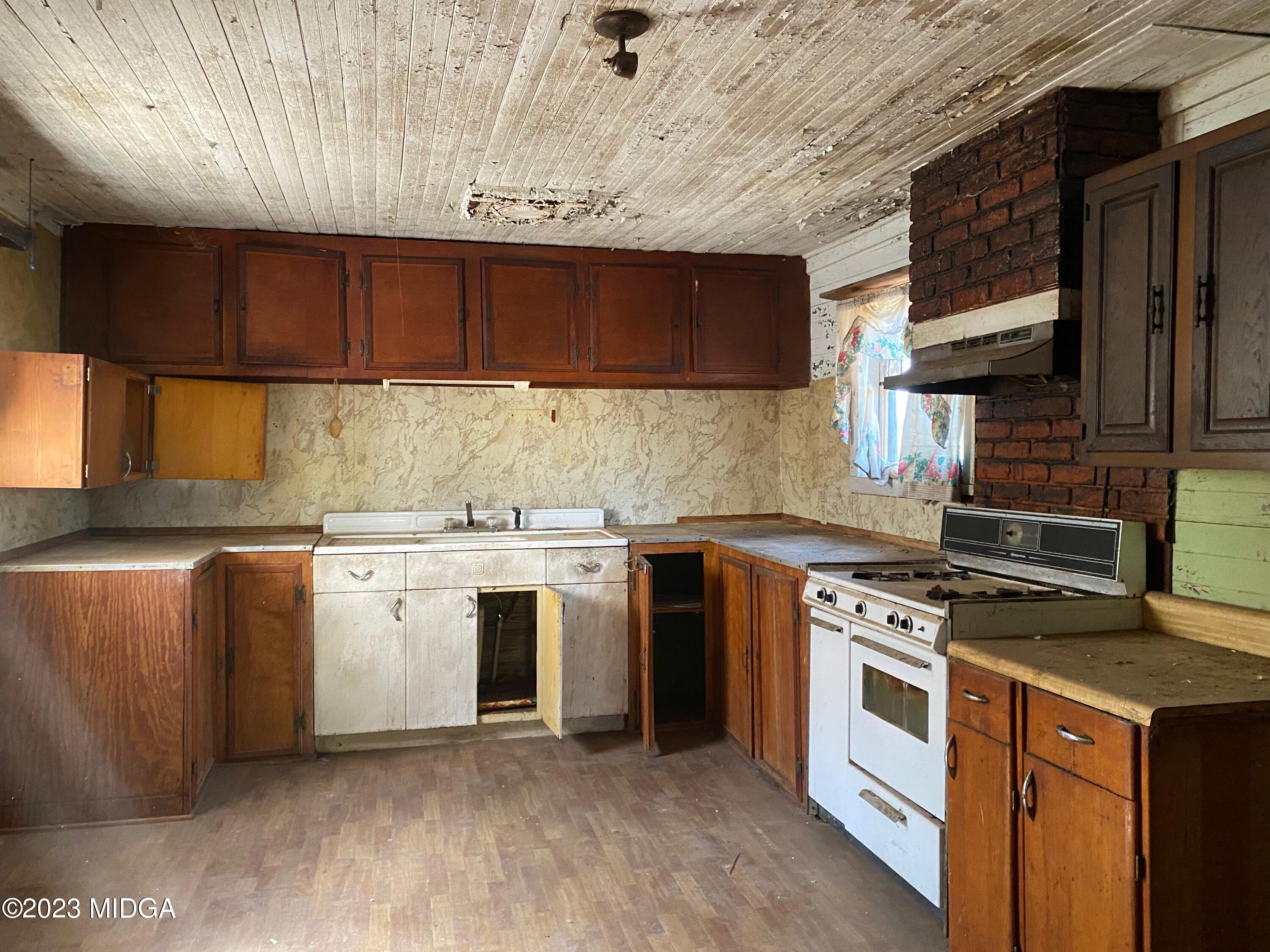 491 Barrow Road Reynolds, GA 31076 - Photo 5 of 56 a kitchen with a stove a sink and a refrigerator