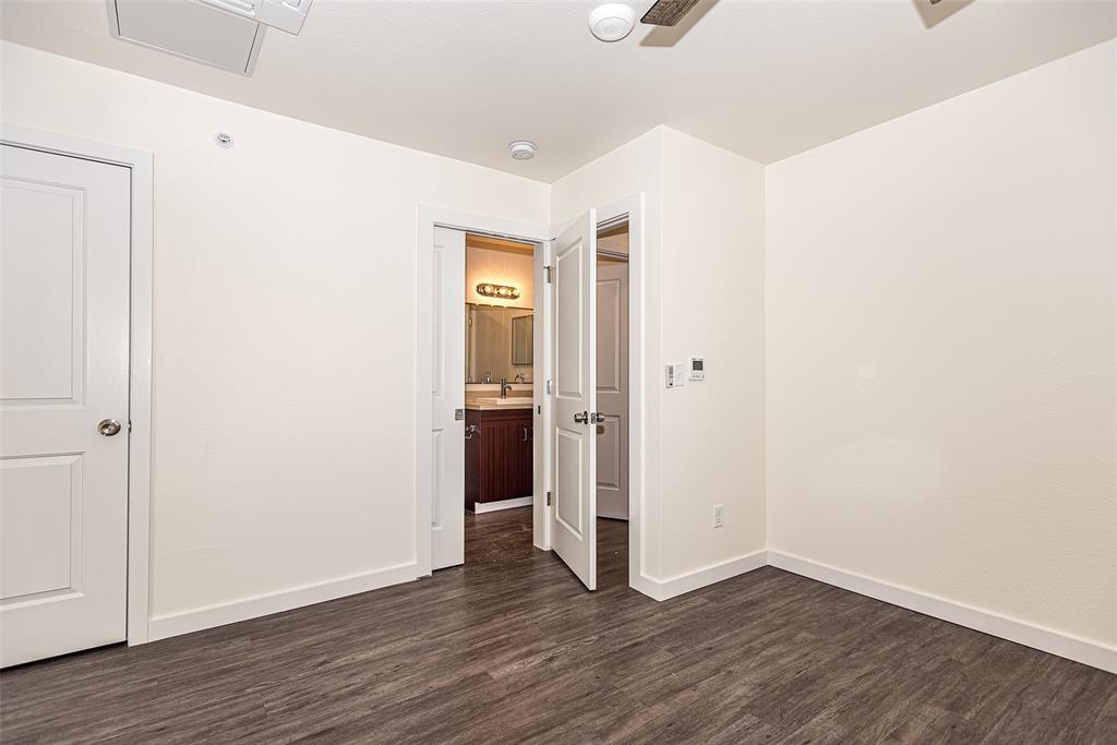 3022 Forest Lane, Unit 110 Dallas, TX 75234 - Photo 11 of 12 a view of a hallway with wooden floor