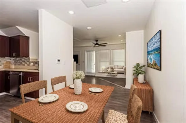 a living room with furniture and a dining table with kitchen view
