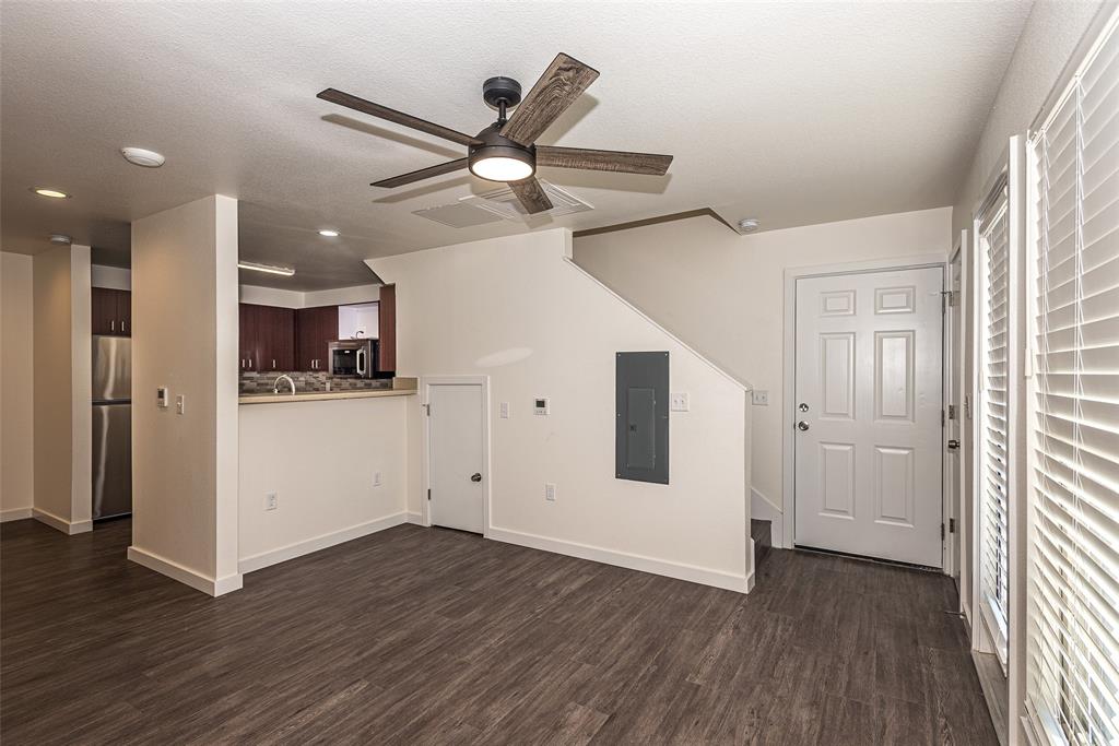 3022 Forest Lane, Unit 110 Dallas, TX 75234 - Photo 7 of 12 a view of a livingroom with wooden floor and a ceiling fan