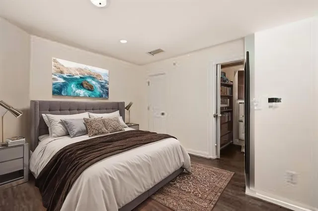 a bedroom with bed and wooden floor