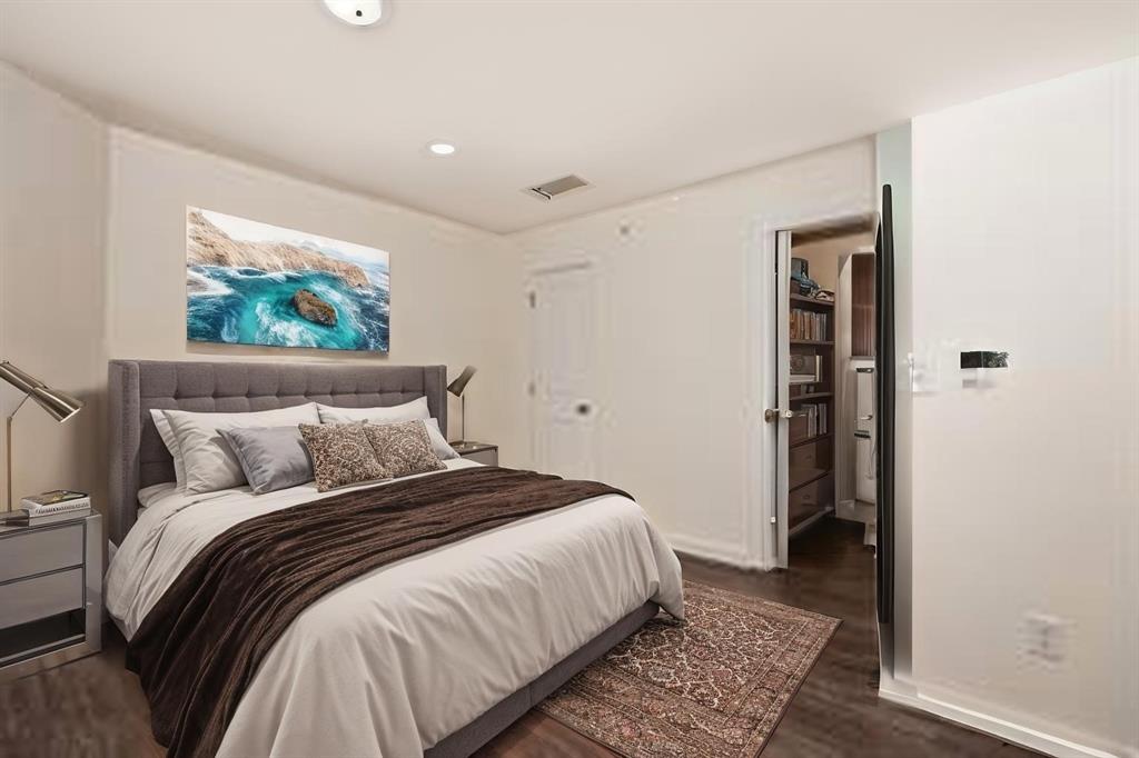 3022 Forest Lane, Unit 110 Dallas, TX 75234 - Photo 8 of 12 a bedroom with bed and wooden floor